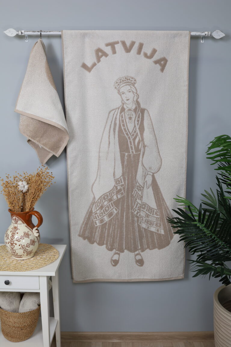 Rankšluostyje pavaizduota tautiniais rūbais apsirengusi latvė. Tai reikšminga ir nacionaliniu požiūriu savita latvių kultūrinio paveldo dalis. Latvijos kultūros tyrinėtojai tradiciniu tautiniu kostiumu vadina žemdirbių drabužį, kuris formavosi ir vystėsi šimtmečiais. Šiuo metu tautinis kostiumas dažniausiai dėvimas prieš latvišką joninių šventę.
