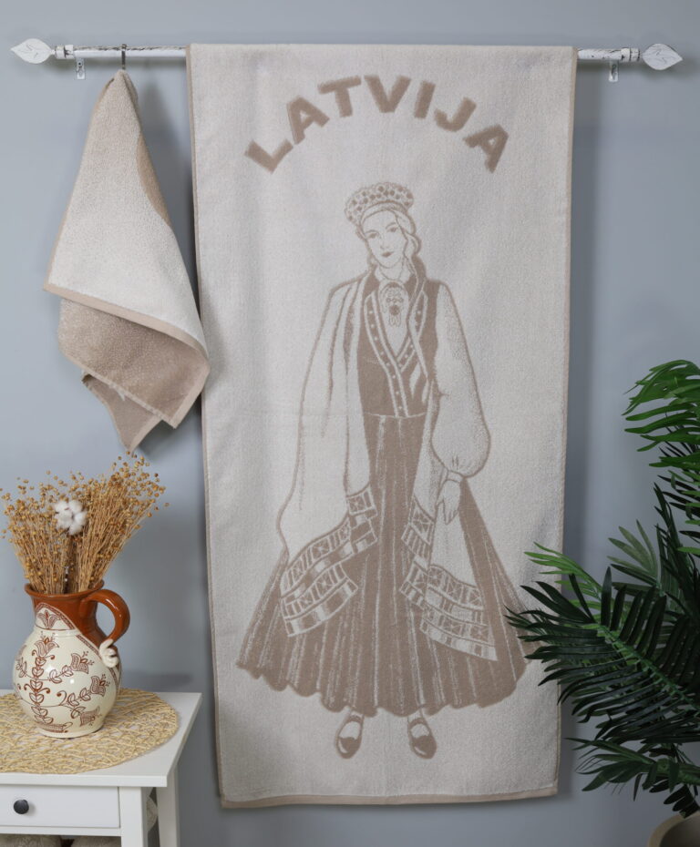 Rankšluostyje pavaizduota tautiniais rūbais apsirengusi latvė. Tai reikšminga ir nacionaliniu požiūriu savita latvių kultūrinio paveldo dalis. Latvijos kultūros tyrinėtojai tradiciniu tautiniu kostiumu vadina žemdirbių drabužį, kuris formavosi ir vystėsi šimtmečiais. Šiuo metu tautinis kostiumas dažniausiai dėvimas prieš latvišką joninių šventę.